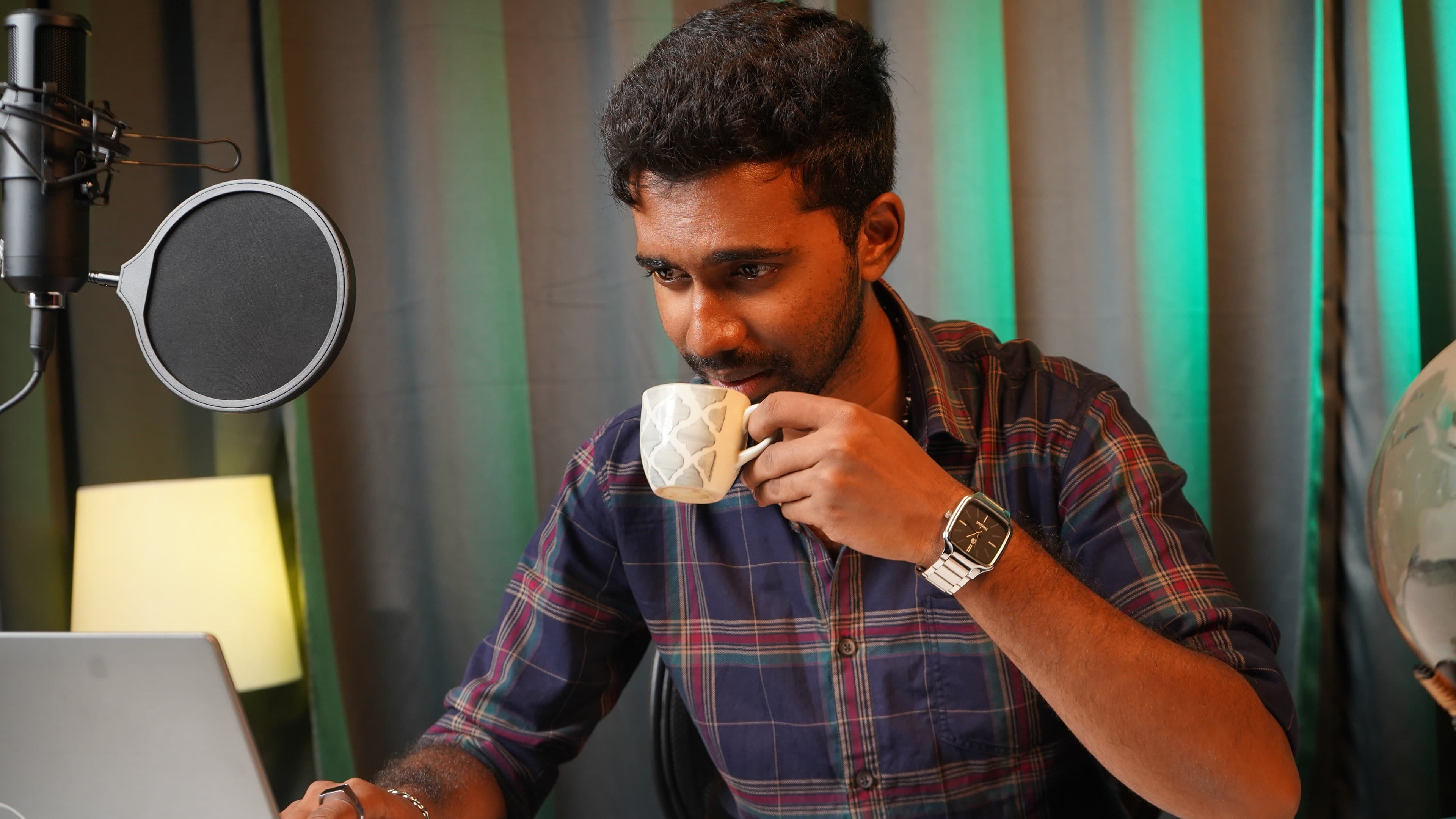 Podcast Production - Host drinking coffee at microphone