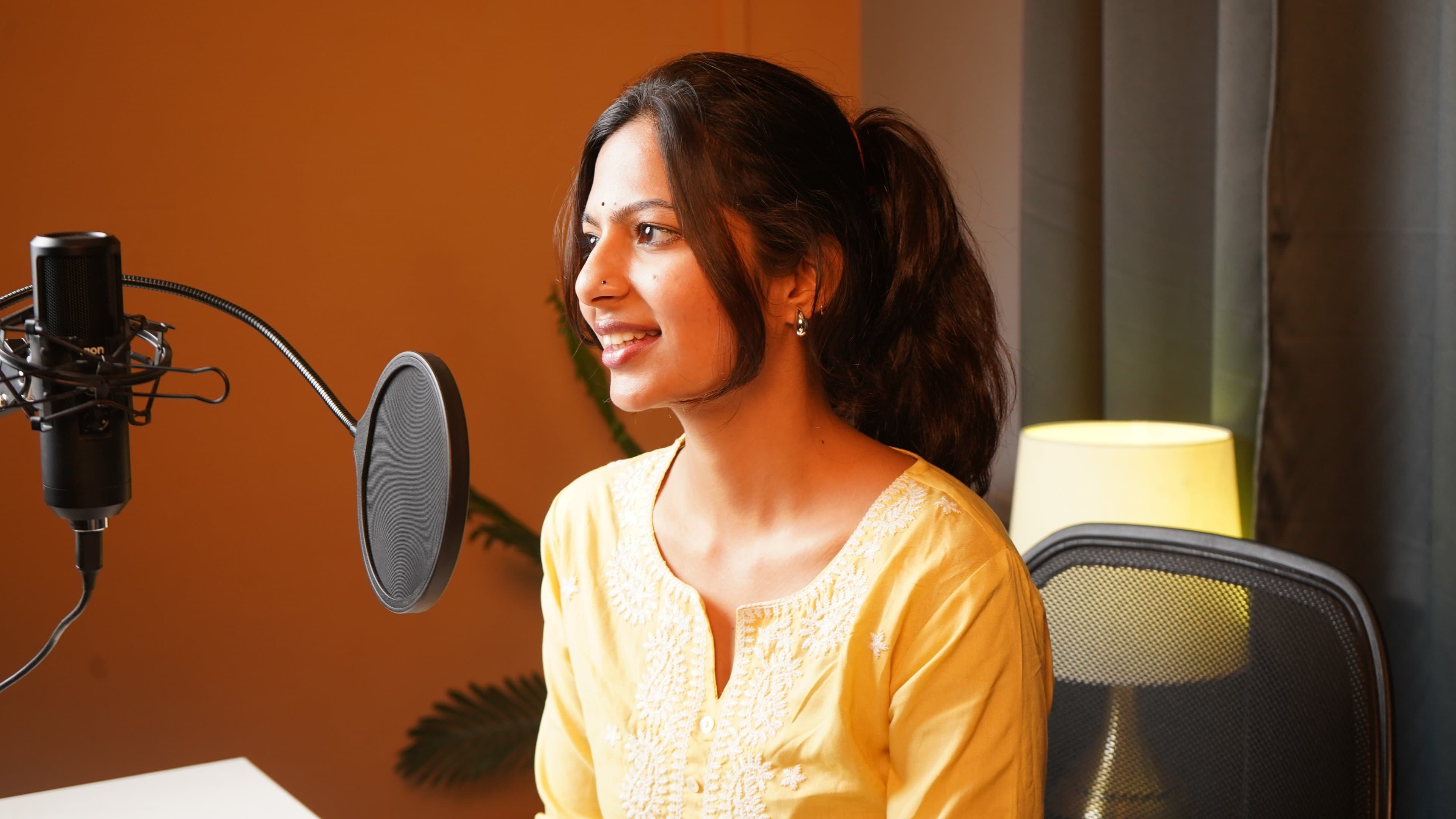 Podcast Production - Guest smiling at microphone